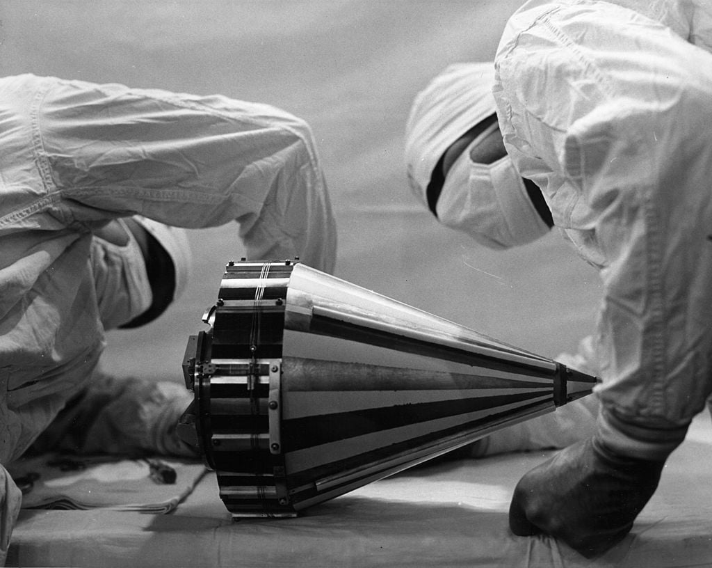 Looking more like surgeons, these technicians wearing "cleanroom" attire inspect the Pioneer III probe before shipping it to Cape Canaveral, Florida.
